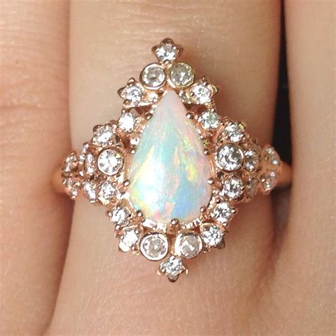 Opal wedding ring. Opal and Diamond Ring. Photo: Quinn's Goldsmith. Go big or go home: This pear-shaped opal engagement ring features a 3.58-carat center stone swirling with color and is surrounded by round white diamonds totaling 0.34 carats. The 14-karat gold band is classic and timeless. $3,400 | Quinn's Goldsmith. 