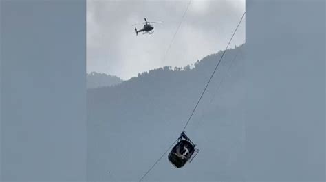 Pakistani rescuers try to free 6 children and 2 men from a cable car hundreds of feet in the air