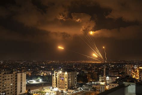 Palestinian militants fire dozens of rockets toward Israel, setting off air raid sirens as far away as Tel Aviv