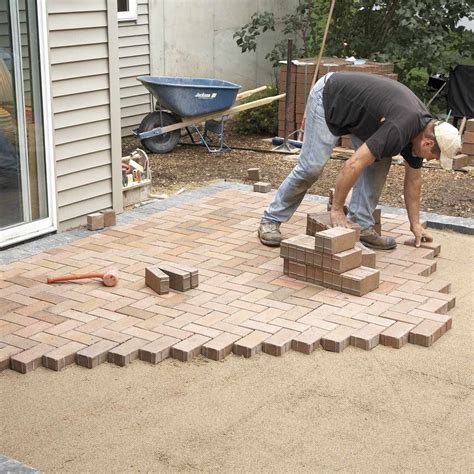 Pavers over concrete. Install a concrete or hard-plastic edging to keep the pavers from shifting. Then, starting from one corner, lay two 2-inch-diameter steel pipes about 6 feet apart and parallel on the compacted base. Cover them with ¼-inch stone, then pull a 2×4 screed board over the pipes to create a flat bed for setting the pavers. 
