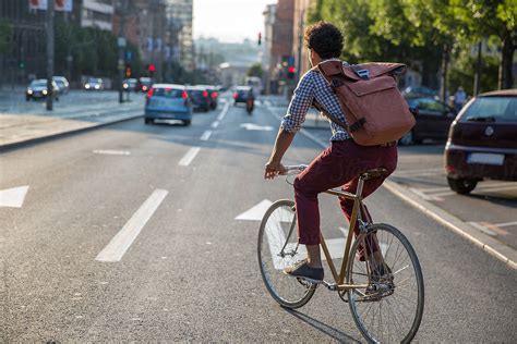 People are walking, a man is riding a bicycle, a boy is walking with …