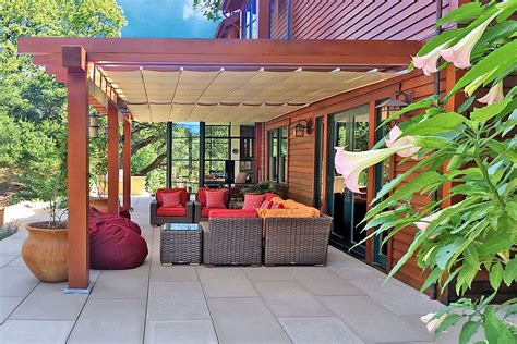 Pergola shade ideas. A steep slope presents itself to the yard and is a focal point. Planting a variety of colors and textures mixed among a few key existing trees changed this eyesore into a beautifully planted amenity for the property. Jimmy White Photography. This is an example of a cottage porch design in San Francisco with a pergola. 