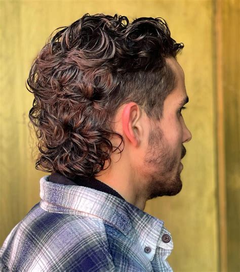 The Permed Mullet. The Permed Mullet is a popular variation of the Classic mullet haircut that has gained popularity in recent years. It typically features a longer, shaggier back section and shorter hair on top and at the sides. The hair is usually layered throughout, with a more defined shape at the back and a looser, more tousled look on top.. 