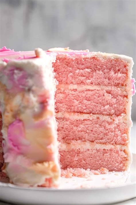 Pink champagne cake. Over medium heat, heat the champagne in a saucepan until it reduces to 1/3 cup. Careful to not let it boil. Remove from the heat and allow it to cool to room temperature. In a large mixing bowl, using an electric hand mixer, beat the cream cheese and sugar together until light and fluffy, about 3 minutes. 