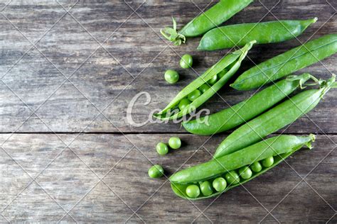 Pod of green peas on wood - Photos by Canva