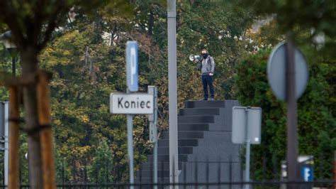 Police in Warsaw detain a man who climbed a monument and reportedly made threats