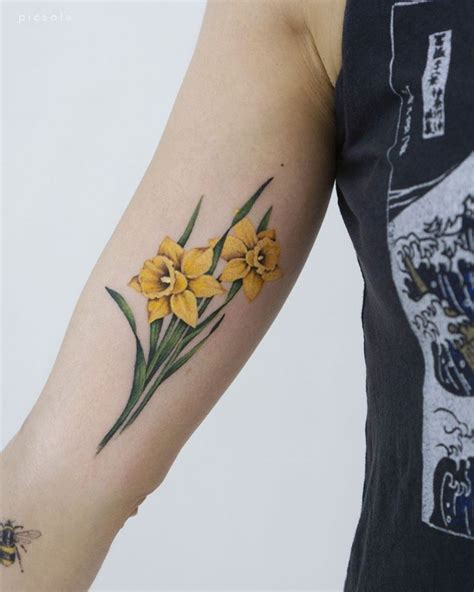 Poppy and daffodil tattoo. A bold outline daffodil tattoo with punchy colors can be such a showstopper without getting too fussy. 4. Fine Line. The detail in fine line tattoos is insane. A delicate, intricately inked daffodil would let that beautiful flower design really shine. 5. Black and white. You can never go wrong with black and white. 