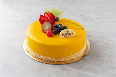 Mango Mousse Bomb. A guest favorite Porto's signature mango mousse on a thin layer of Rosa's original sponge cake with passion fruit cr-meux. Finished with mango glaze, finely shredded coconut, and white chocolate d-cor. $3.85.. 