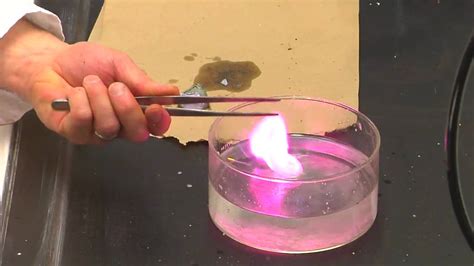 Potassium in water. A reaction of small piece of potassium metal with water. The flame you see is actually burning hydrogen given off but is colored pink due to potassium vapor. 