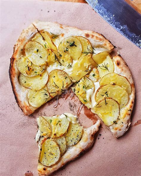 Potato pizza. Place pizza stone in oven and preheat oven to 400 degrees F. Toss and stretch pizza dough into a 14-inch circle. Once oven is preheated, carefully remove pizza stone from oven and spray with cooking spray. Carefully place dough on stone. Place potato slices on top of dough in a circular pattern. 