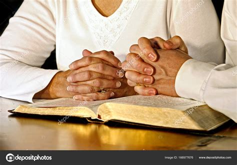 Praying hands couple reading bible Stock Photos and Images