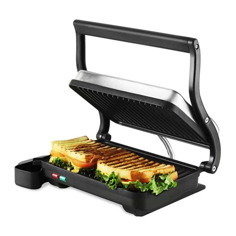 Press grill. USE AS A CONTACT GRILL OR PANINI PRESS 1. Ensure the drip tray is correctly inserted into the grill. 2. Ensure the cooking plates are correctly inserted and securely locked into position. 3. Place the grill on a flat, dry surface. Ensure there is a minimum distance of 8" (20cm) of space on both sides of the appliance. 4. 