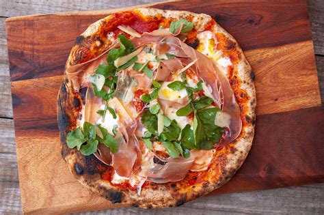 Prosciuttos pizza. Top with the mozzarella, prosciutto, Calabrian chiles and oregano. Place in the oven, constantly rotating as to not burn the crust, until the crust is golden brown and the toppings are sizzling, 1 ... 