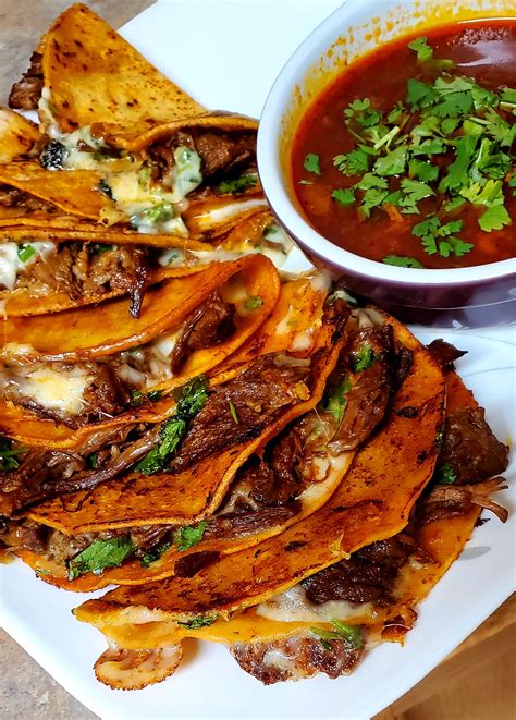 Quesa birria tacos. Stir in the cinnamon sticks, cloves and beef stock. Cover and transfer to the oven. Braise the meat for 3 hours. Remove the Birria stew from the oven and skim off some of the fat. Reserve the fat to cook the tacos. With a slotted spoon, remove the stew meat to a platter and shred with two forks. 