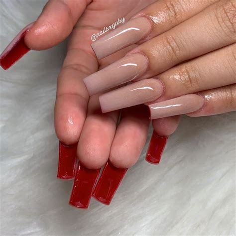 8. Long Coffin Mani. If you're a fan of long nails, you'll love this one. This nail design has red glitter on the thumb and little fingernail. The other nails are painted with glossy nude polish and bright red at the tips. Image by @marineida_nail_creations via Instagram. 9. Bright Red Croc Nails.. 