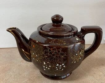Redware teapot.  Brown and hand painted with flowers.  With its vintage appe...