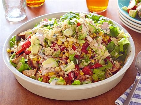 Set aside. For the salad: Put the chicken, cabbage, romaine, kale, carrots, edamame, almonds, peanuts and bell peppers in a large bowl. Pour about two-thirds of the dressing over the salad and ...