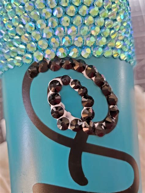 Making a rhinestone tumbler requires several materials and tools. First, you will need a stainless steel or plastic tumbler cup. You can find these at craft stores or online retailers. Next, you'll need an adhesive to attach the rhinestones to the cup such as E6000 glue or hot glue gun with sticks..