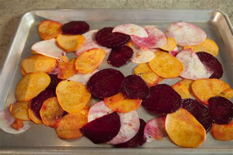 Preheat oven to 400°F. Line two large rimmed baking sheets with nonstick foil. Cut carrot, parsnip, and potato into 1/8-inch-thick slices using vegetable slicer or thin slicing blade of food processor. Combine vegetables in large bowl and generously spray with olive oil nonstick spray, tossing to coat evenly.. 