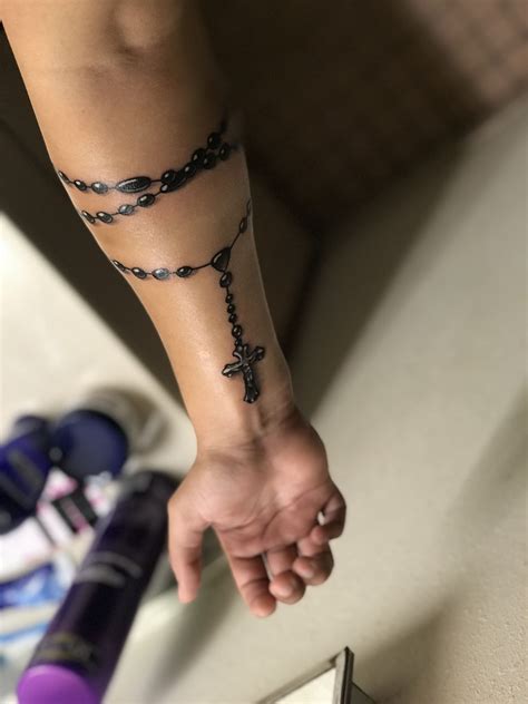 1. The rosary wrapped around an arm tattoo is often referred to as a "bracelet rosary". 2. The tradition of wearing a rosary as a tattoo dates back to ancient Egypt, where some Pharaohs would tattoo religious symbols onto their bodies as a form of personal devotion. 3.. 