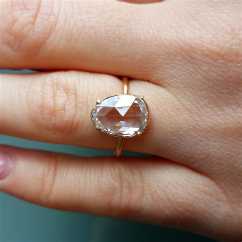 Rose cut diamonds. In all of its shimmer and grace, this dainty rose cut diamond features pavé details along the band in its fine 18k gold setting. Set yourself apart with a unique and endearing style such as this one. 
