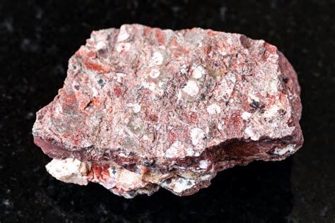 Ryolite. This rhyolite specimen, from the Sutter Buttes of northern California, has visible phenocrysts of quartz. Rhyolite is often pink or gray and has a glassy groundmass. This is a less typical white example. Being high in silica, rhyolite originates from a stiff lava and tends to have a banded appearance. Indeed, "rhyolite" means "flowstone" in Greek. 