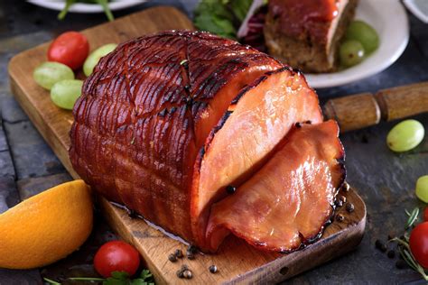 Place the ham, flat side down in a roasting pan, and cover tightly with foil. Roast 12-15 minutes per pound (or according to package directions). Meanwhile, combine glaze ingredients and bring to a boil. Turn heat down and simmer 2-3 minutes. Cool.. 