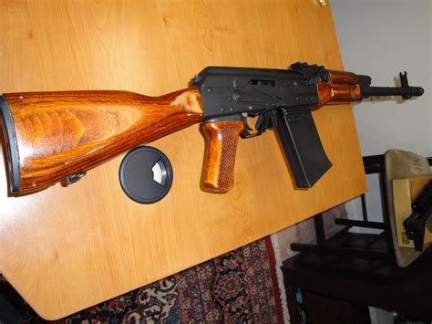 Any stock meant for stamped AKs will fit. A standard lower handguard will need some material on the inside removed to fit over the 12 gauge barrel. Or Ironwood Designs sells furniture mostly ready to go. Some fitting is always necessary. You'll need a lower handguard retainer; there are both bolt-on and press-on designs available.. 