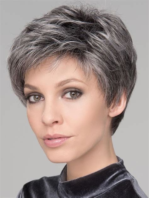 1. Feathered Pixie Haircut. This platinum blonde pixie is perfect for women over 60 looking to embrace their gray hair. The feathered fringe is a little longer around the face to add a feminine touch to a short haircut. Don't forget to use purple shampoo to keep your hair color bright and brass-free. @presleypoe.. 