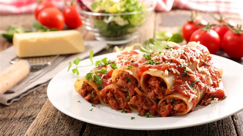 Coat the bottom of a rectangular baking dish (9 x 13 inches) with sauce. Arrange the prepared crepe cannelloni in the dish. Ladle sauce over the cannelloni, just enough to cover. If desired, sprinkle the top with shredded mozzarella. Bake covered in a 350 degrees F preheated oven for 20 minutes.