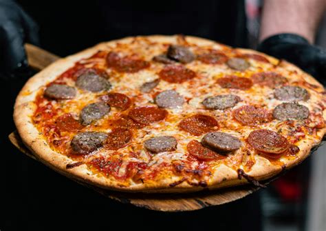 Sausage pizza. Set aside. To assemble: Preheat oven to 500°F (260°C). Generously grease the 12-inch (30-cm) Cast Iron Skillet with softened butter. Gently press the shredded parmesan cheese at the bottom & sides. Lay your rolled dough on top and using your fingers, press the dough into the cast iron pan. 