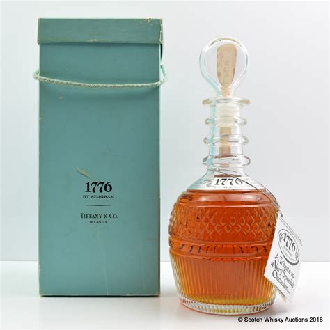 1776 Tiffany & Co Seagram's bottle with original box. This is sold a collectible bottle, not for the content of the bottle. DESCRIPTION:Whiskey crystal decanter by Tiffany & Co. Features a vertical arching lines on top of cubic cuts garnishing the lower half of the decanter..