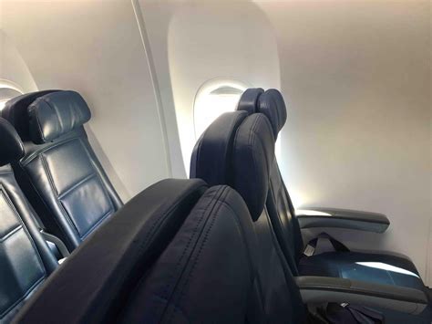I always book this seat when flying on a 737-900ER. The armrest is connected on the wall/door, not the seat. Even though the seat isn't smaller, you loose a little space because of the emergency exit door protruding outwards a little. Hope this helps. Check seatguru.. 
