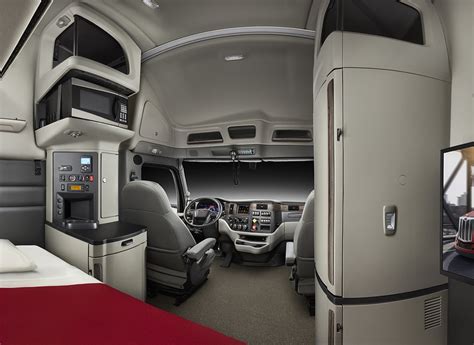 Modern red semi truck brown interior gorgeous place to work The interior of a modern luxury red semi truck made in shades of brown plastic. Through the open door with wood paneling truck visible part of the seat with shock absorbers and the dashboard console with air vents. semi truck interior stock pictures, royalty-free photos & images. 