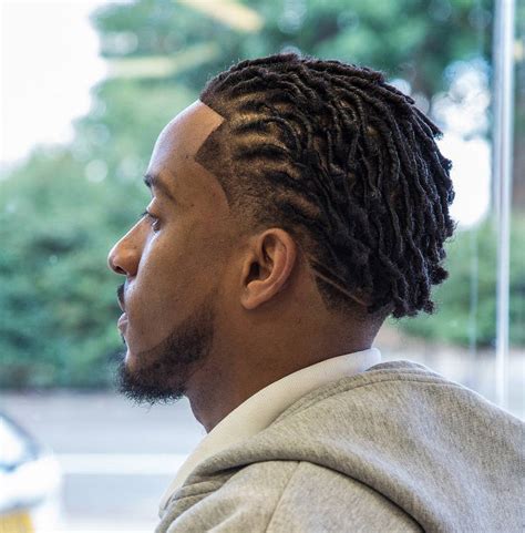 This hairstyle is a classic short-side long top hairstyle with bald faded sides and nape and around 10 or 15 medium-thick dreads installed on the crown area and swept on one side of the head for a relaxed look. 4. Red and Green Medium Dread Hairstyle For Men. Source.. 