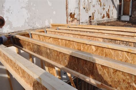 Should I use solid lumber or plywood to repair a floor joist?