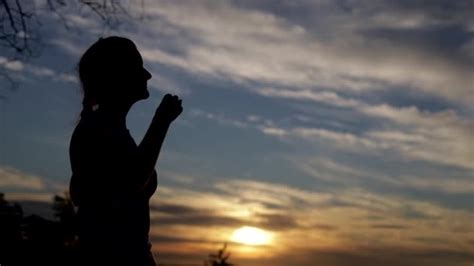 Silhouette of a woman praying with Amazing dramatic sky sunset …