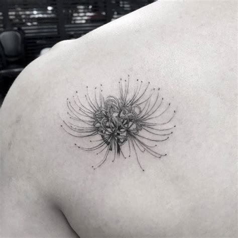 Single needle spider lily tattoo on the left shoulder