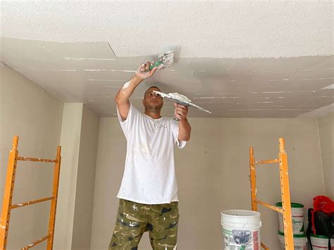 Skim coat ceiling. In Step 4, use the squeegee or taping knife at a right angle. For the first coat, you should use it vertically, dragging downward from the ceiling and upward from the floor. For the second coat, drag the squeegee horizontally in your section. For a third coat, go back to using the squeegee vertically in the section. 