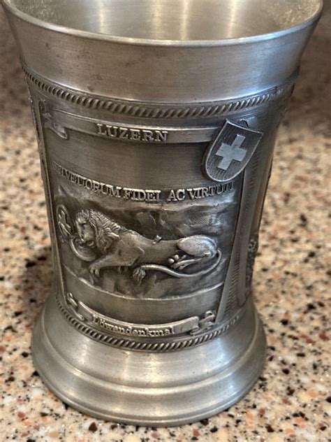 This is a very nice pewter stein that is about 8 tall. It is made in Germany by SKS Zinn. It is marked 95% pewter. Nice German city designs around the stein. The base is 4 3/8 diameter. Good conditi. 
