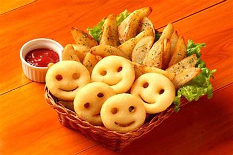 Smiley potato fries. Smiley faces shaped Stock Photo. Happy French fried potato smiley faces with ketchup Stock Photo. Smiley face fried potato dip with tomato sauce serve in basket ... 