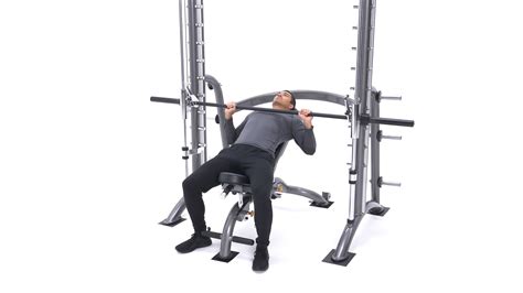 Smith machine and bench press. Grip the bar slightly wider than shoulder-width apart. Take a breath and hold it, and unrack the bar. Lower the bar with control, until it touches your upper chest. Push the bar up while exhaling. Take another breath in the top position, and repeat for reps. Smith incline bench press differs from incline barbell bench press primarily by its ... 