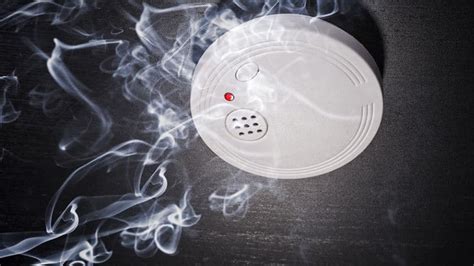 Locate the reset button on the smoke detector. It is usually present o
