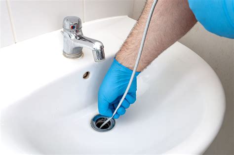 Snaking a drain. Step 2: Sanitize & Empty Out. Removing any standing water around the clog first allows the snake better access. For tub drains, bail water using cups and the bucket. With sinks, plug the second basin and bail water, then unplug to let it fully drain. Run some hot water too to sanitize and flush pipes beforehand. 