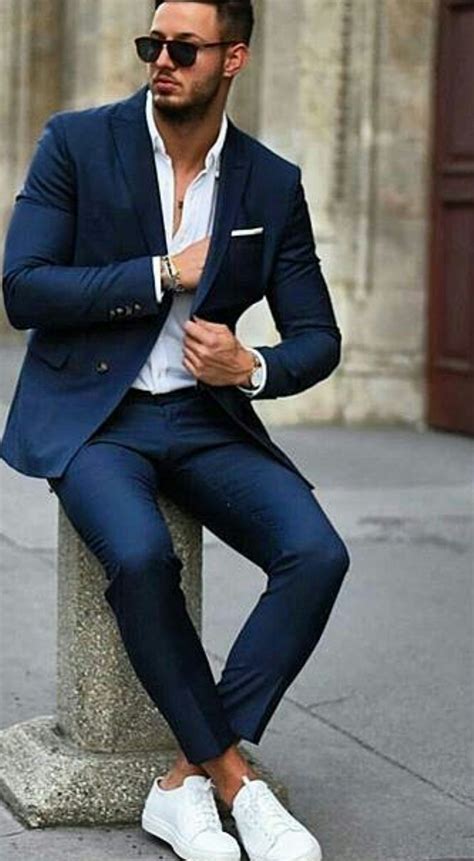 Sneakers with a suit. 1. Formal Blue Suit & White Sneakers. Blue and white is a great combo, especially when wearing a suit with sneakers. The white chunky sneaker and cropped … 