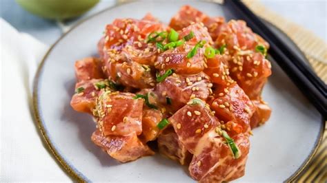 Spicy ahi. Slice the tuna into 1-inch cubes. Mince the onion. Thinly slice the green onions. Mix them in a bowl with the soy sauce, sesame oil, garlic, ginger, kosher salt and Sriracha. Serve immediately, but for most authentic flavor marinate in refrigerator for 15 minutes to 1 hour. 