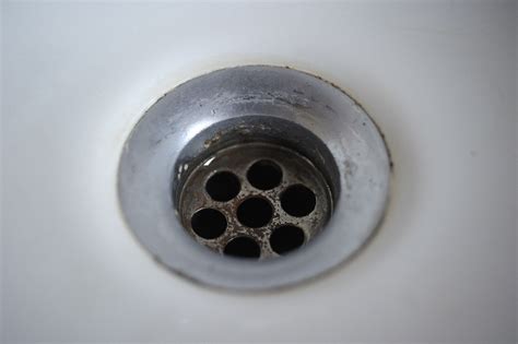 Stinky sink drain. 1. Attach a brass tailpiece to the bottom of the basket strainer. Take a brass tailpiece and line up the threads with the threads on the bottom of the basket strainer. Screw on the tailpiece as tightly as you can with your hands. You can find brass tailpieces at hardware stores and home improvement stores. 
