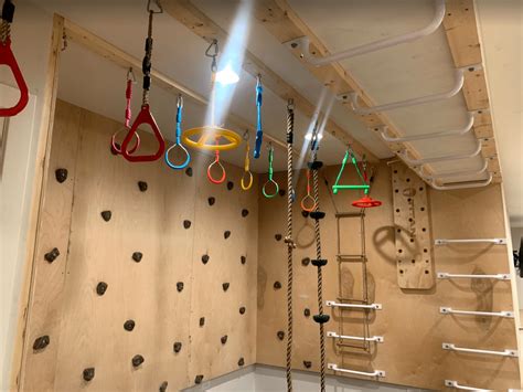 Strength training for climbing.  Indoor climbing set with monkey bars, rock wal...