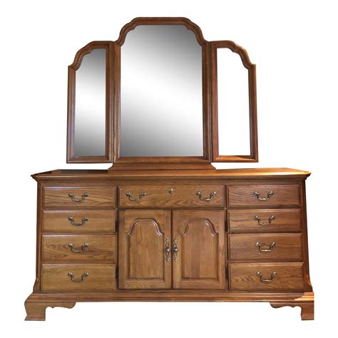 Sumter cabinet company. A two drawer nightstand by Sumter Cabinet Co. This medium stained wooden nightstand features a beveled overhanging top, two drawers with brass tone batwing pulls with carved scrolling accents on th... 