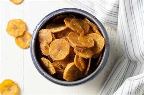 Sweet plantain chips. 2. Wash and peel the plantains. Cut them into very thin slices using a mandoline or a sharp knife. Place the slices into a medium mixing bowl. 3. In a small bowl or ramekin, mix together the curry powder, paprika, salt, and grapeseed oil. 4. Pour the spice-oil mixture onto the plantain slices. 